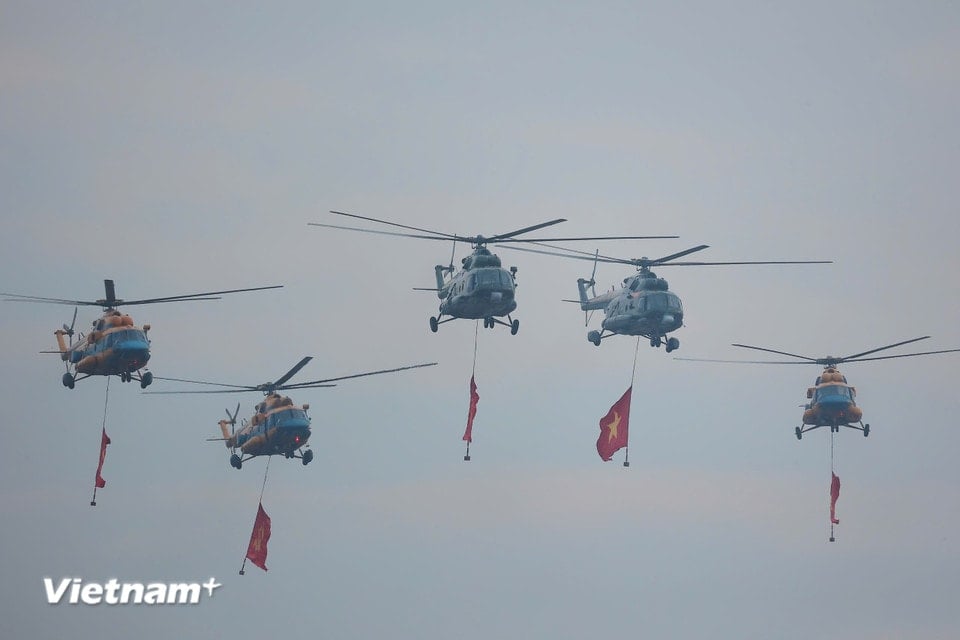 Военно-воздушные силы провели салют, неся партийный флаг и государственный флаг, развевающиеся над площадью Бадинь. (Фото: PV/Vietnam+)