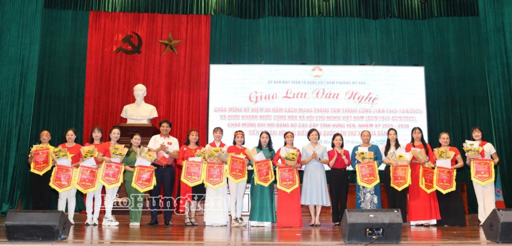 O camarada Tran Thi Thanh Thuy, membro do Comitê Permanente Provincial do Partido, secretário do Partido e presidente do Conselho Popular do bairro My Hao, entregou bandeiras de lembrança às unidades participantes do programa de intercâmbio cultural.