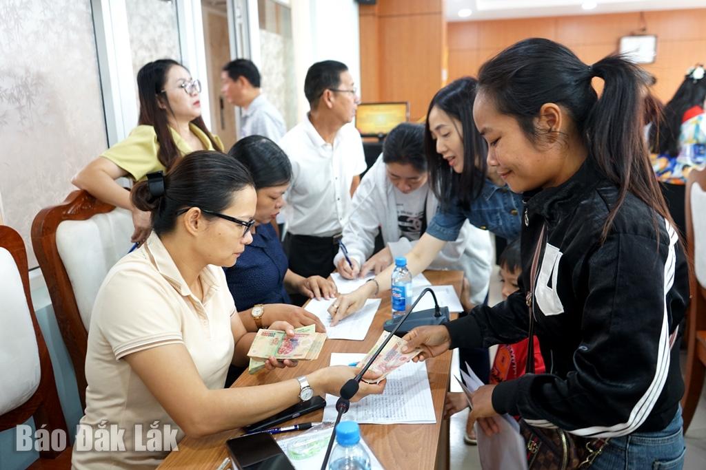 Mme H Yol Eban, du village d'Ea Bong, quartier de Buon Ma Thuot (couverture droite) représente les membres de la famille lors de la réception d'argent.