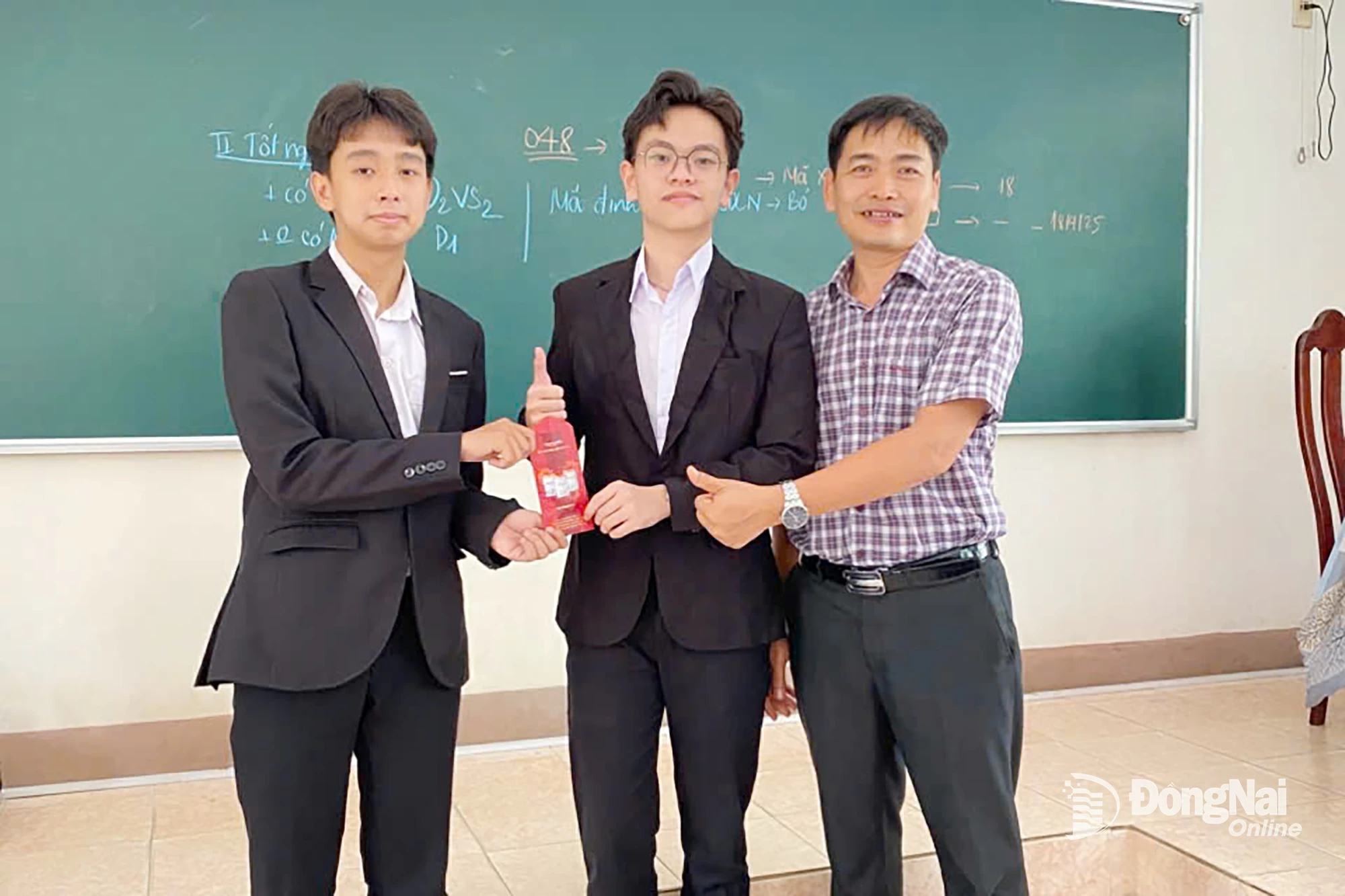 Em Nguyễn Thanh Hải, lớp 12C chuyên Hóa, thủ khoa khối A00 (đứng giữa) chụp hình với thầy Nguyễn Văn Thoa, giáo viên chủ nhiệm lớp
