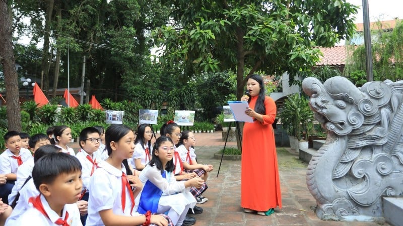 Các em học sinh Trường Tiểu học Xuân La (Hà Nội) học môn Lịch sử địa phương ngay tại di tích đình Quán La (phường Xuân La). (Ảnh: Giang Nam)