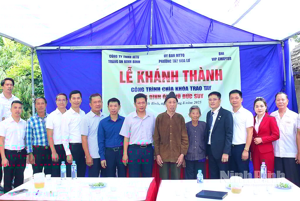 Đại diện lãnh đạo phường Tây Hoa Lư và các doanh nghiệp chụp ảnh lưu niệm với gia đình ông Vũ Đức Sỹ trong lễ khánh thành nhà mới.