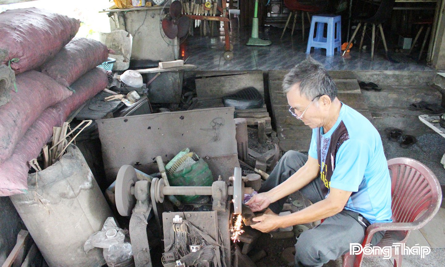 Thợ rèn Nguyễn Văn Hiền, ngụ phường Cao Lãnh đang thực hiện công đoạn mài bén cây dao.