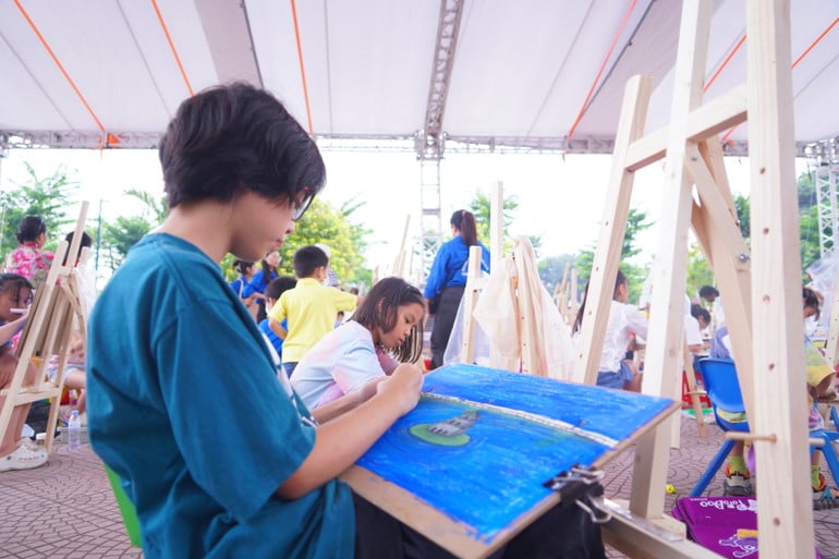 Các họa sĩ nhí say sưa sáng tác về Hà Nội qua cái nhìn ngây thơ của các em.
