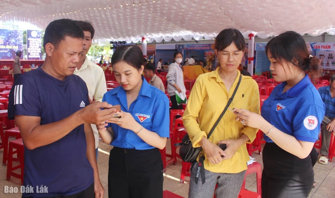 đoàn viên thanh niên hướng dẫn người dân khai tahcs các ứng dụng số trên điện thoại. Ảnh: T. Hương