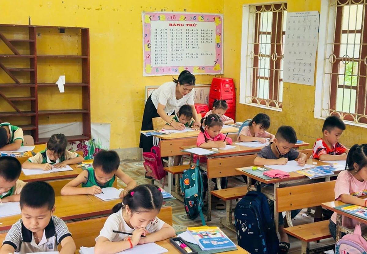 Giáo viên trường TH Thổ Bình xã Bình An hướng dẫn học sinh tập viết.