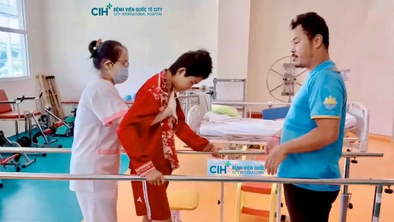 Bệnh nhi Toun Sreynich tập hồi phục với sự hỗ trợ của bác sĩ. 