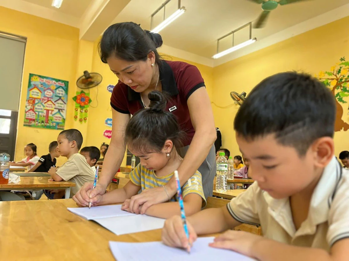 Giáo viên Trường tiểu học Minh Quang, xã Bình Xa hướng dẫn học sinh cách cầm bút.