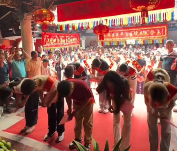 During the ceremony, successful new students wearing red ribbons bearing the words “glory of the nation” offered incense and bowed before the ancestral altar. (Photo: SCMP/Jimu)