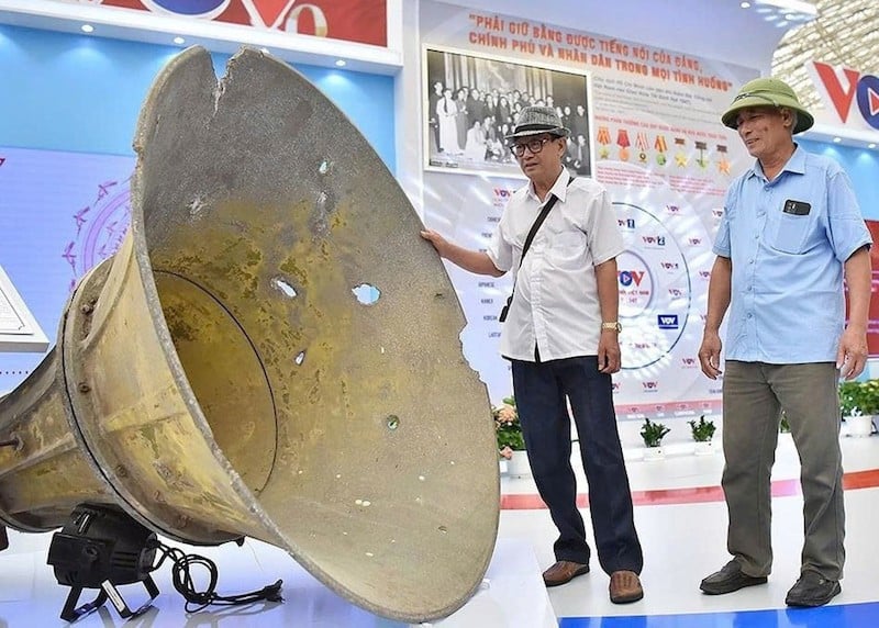 Orang-orang mengunjungi pengeras suara yang ditempatkan di paralel ke-17 selama tahun-tahun perlawanan terhadap AS, sekarang dipajang di stan Suara Vietnam di Pameran Nasional.