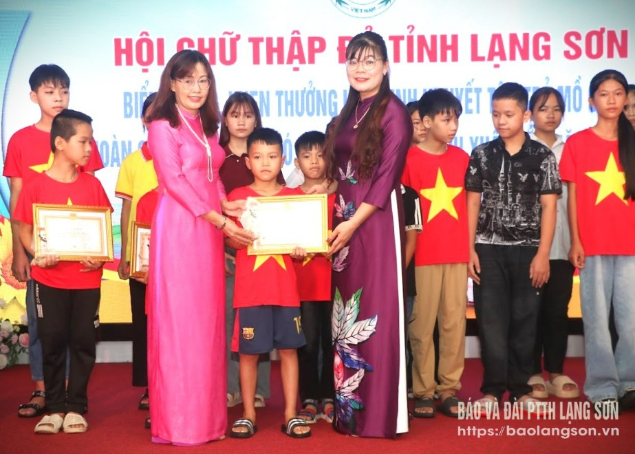 Đại diện Hội Chữ thập đỏ tỉnh trao giấy khen cho các học sinh khuyết tật, trẻ mồ côi, trẻ có hoàn cảnh khó khăn