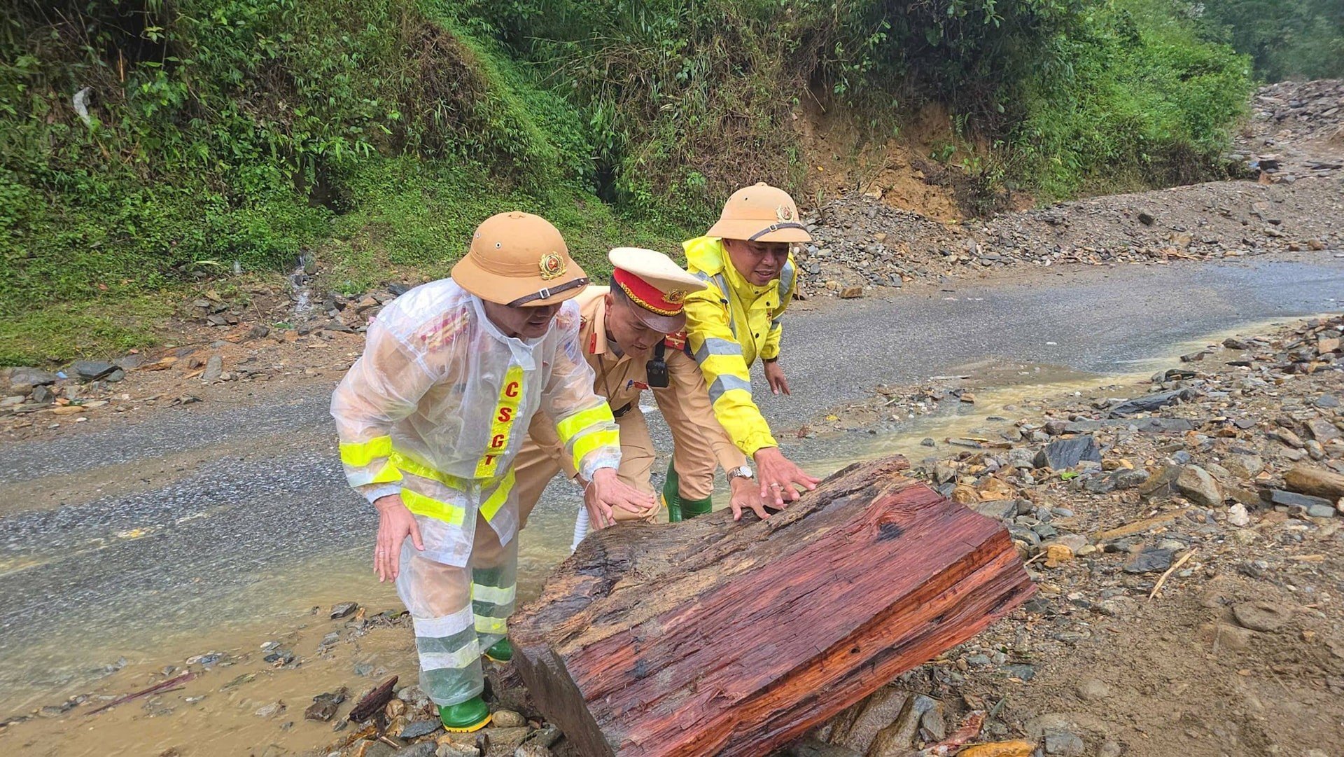 Từng hòn đá, khúc cây lớn được di chuyển vào vệ đường để đảm bảo an toàn cho các phương tiện và người dân.