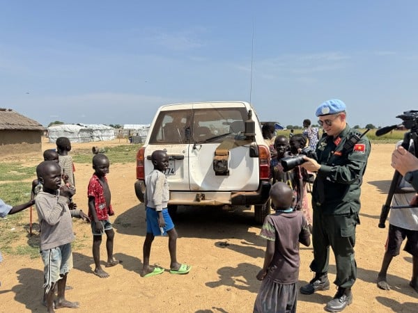 Thiếu tá Nguyễn Thế Anh chụp ảnh và trò chuyện với trẻ em ở Nam Sudan trên đường làm nhiệm vụ.