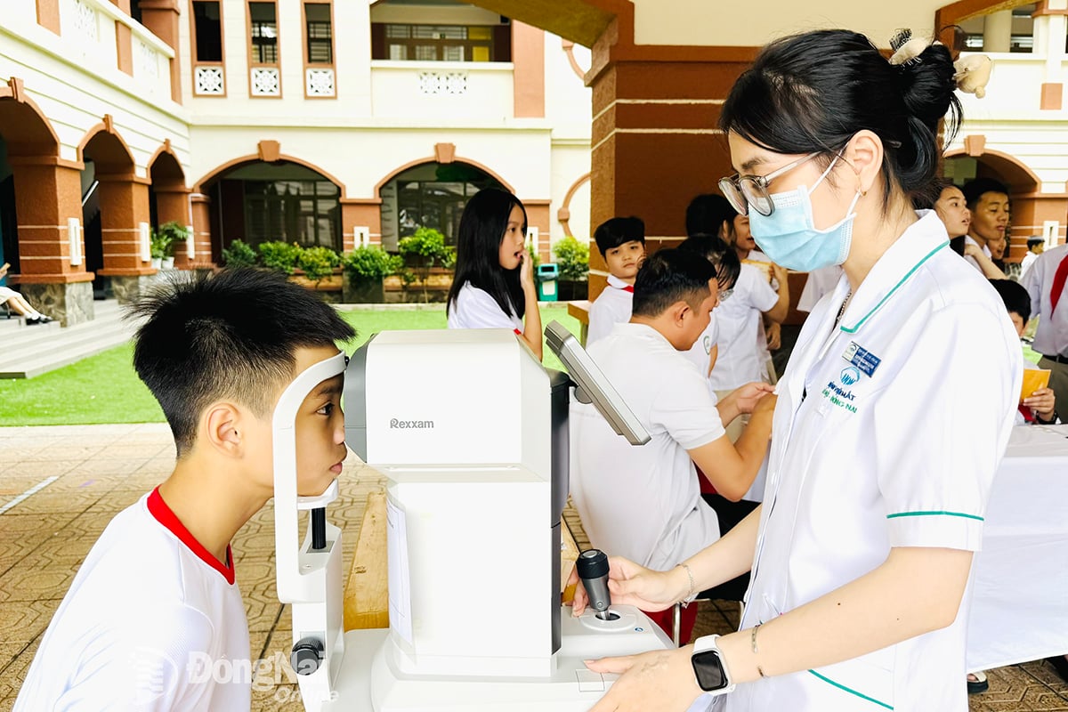 Nhân viên y tế Bệnh viện Mắt Hà Nội - Đồng Nai khám sức khỏe về mắt cho học sinh trên địa bàn tỉnh.