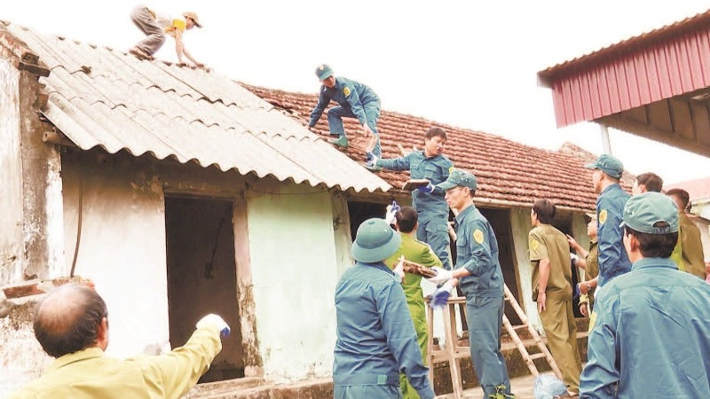 កងកម្លាំងចូលរួមជួយឧបត្ថម្ភថ្ងៃធ្វើការដើម្បីជួយគ្រួសារក្រីក្ររុះរើផ្ទះដែលទ្រុឌទ្រោមនៅខេត្ត Ha Nam។ (រូបថត៖ nhandan.vn)