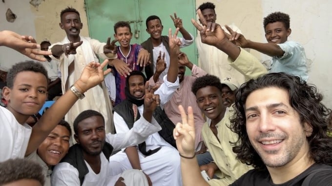 Micheael Zervos chụp ảnh cùng những người trẻ ở Port Sudan. Ảnh: Guinness World Records