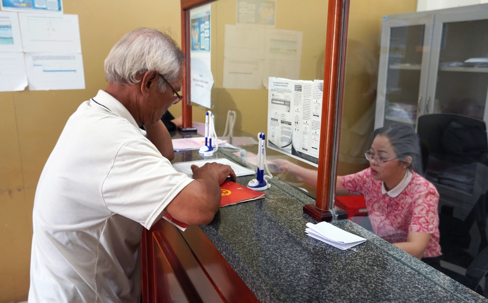 Lidé vyřizují administrativní úkony na pozemku v Centru služeb veřejné správy obce Quang Ninh - Foto: L.C