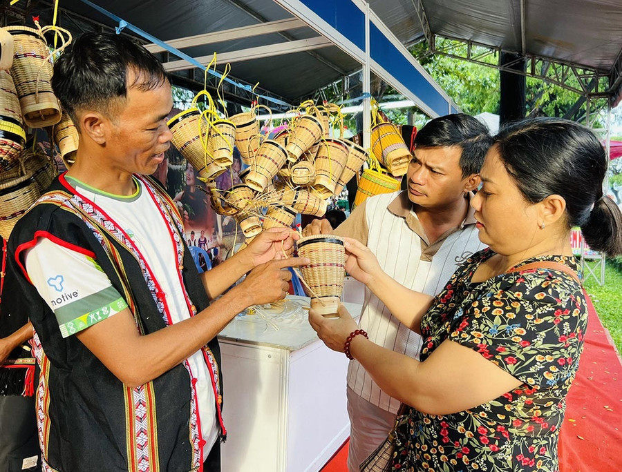 Anh Rinh (bìa trái, làng Ngơm Thung, xã Ia Băng) giới thiệu đến khách hàng sản phẩm gùi truyền thống với nhiều kích cỡ. Ảnh: M.N