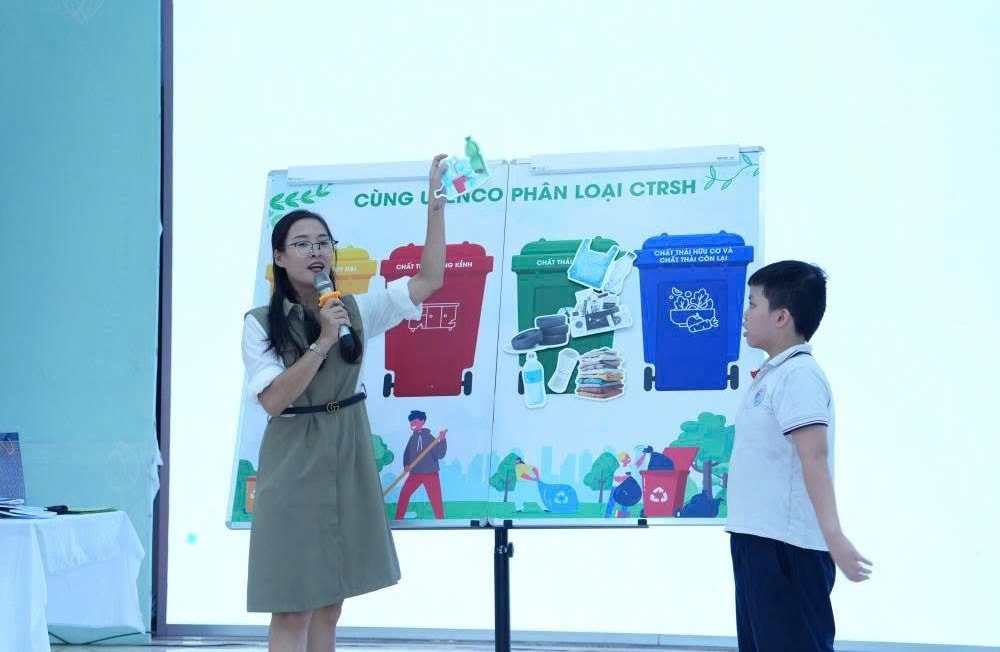 The staff of Do Thi Environmental Company Limited, Ha Noi, guides students of Hoang Dieu Primary School, Phuong Ngoc Ha, on how to classify household waste at the source.-Anh Duc Hiep.jpg
