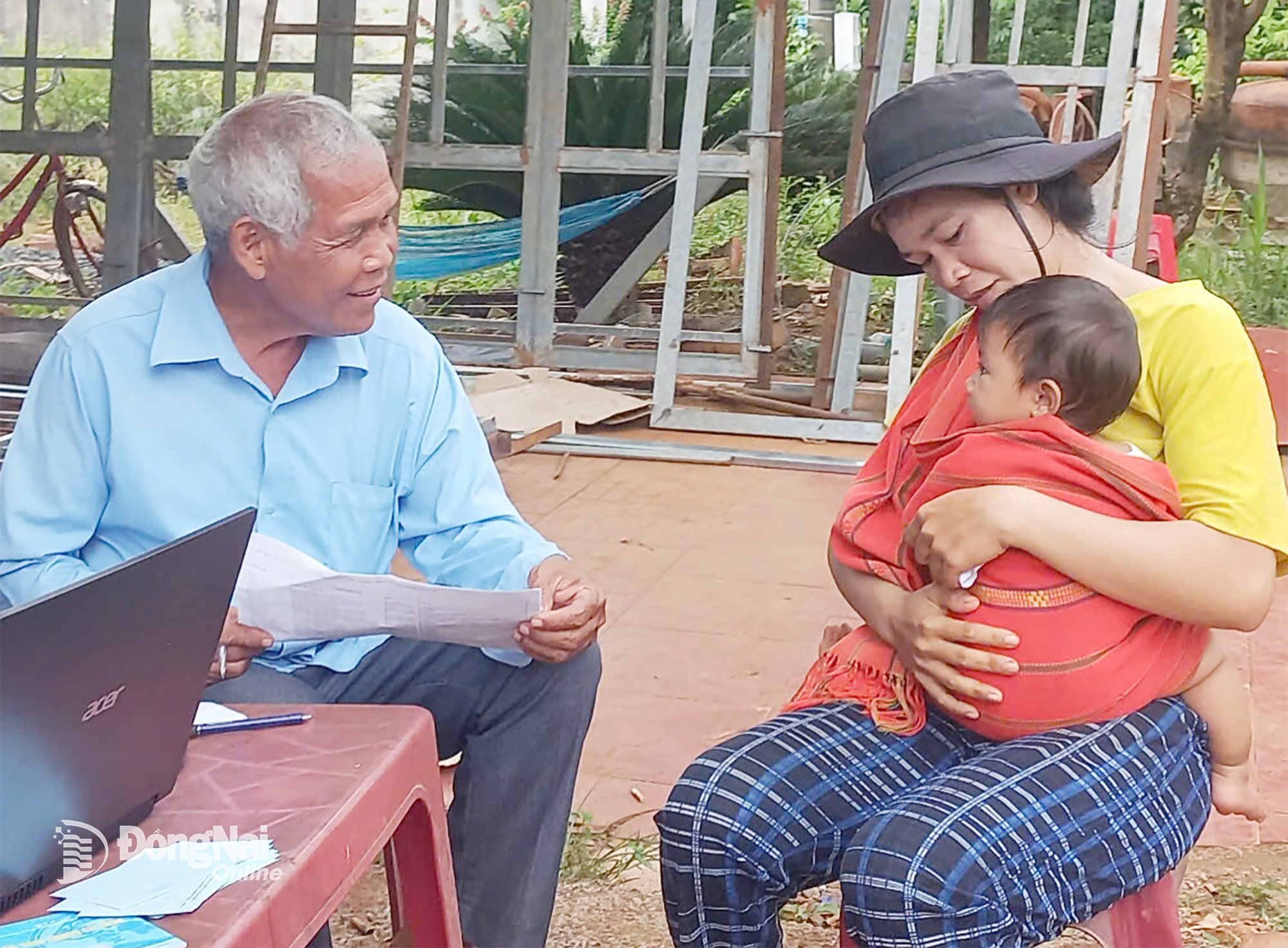 Ông Điểu Đé
(thôn Hai Căn,
xã Phú Nghĩa)
trò chuyện
với người dân
đưa con
đi tiêm chủng.
Ảnh: C.T.V