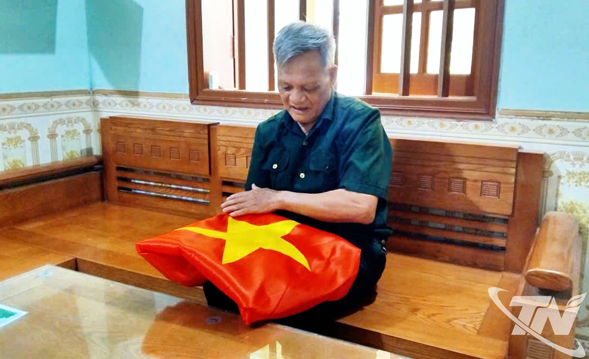 លោក ថាង លើកទង់ជាតិដោយគោរពនៅឯគេហដ្ឋានរបស់លោក។