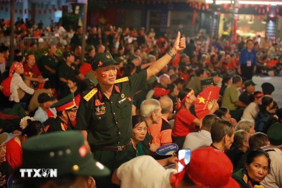 ប្រជាជនបានប្រមូលផ្តុំគ្នាដោយទង់ជាតិក្រហម និងផ្កាយពណ៌លឿង រង់ចាំជាមួយគ្នាក្នុងឱកាសនៃការដង្ហែរក្បួនដើម្បីអបអរសាទរខួបលើកទី 80 នៃទិវាជាតិ។ (រូបថត៖ Khanh Hoa/VNA)