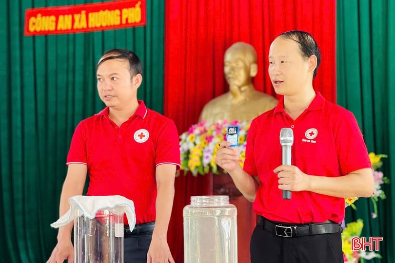 Cán bộ Hội Chữ thập đỏ tỉnh hướng dẫn người dân xã Hương Phố cách bảo quản nguồn nước và xử lý môi trường sau thiên tai.
