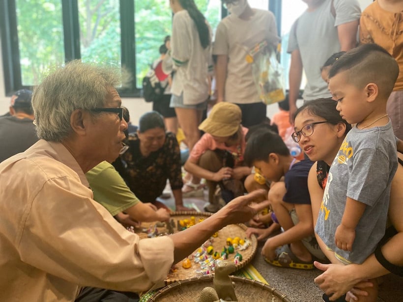 វិចិត្រករណែនាំសាធារណជនក្នុងការធ្វើរូបចម្លាក់ដីឥដ្ឋ។