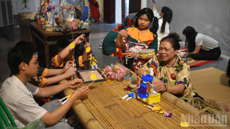 Nghệ nhân Nguyễn Thị Tuyến giới thiệu đồ chơi Tiến sĩ giấy với các bạn trẻ.