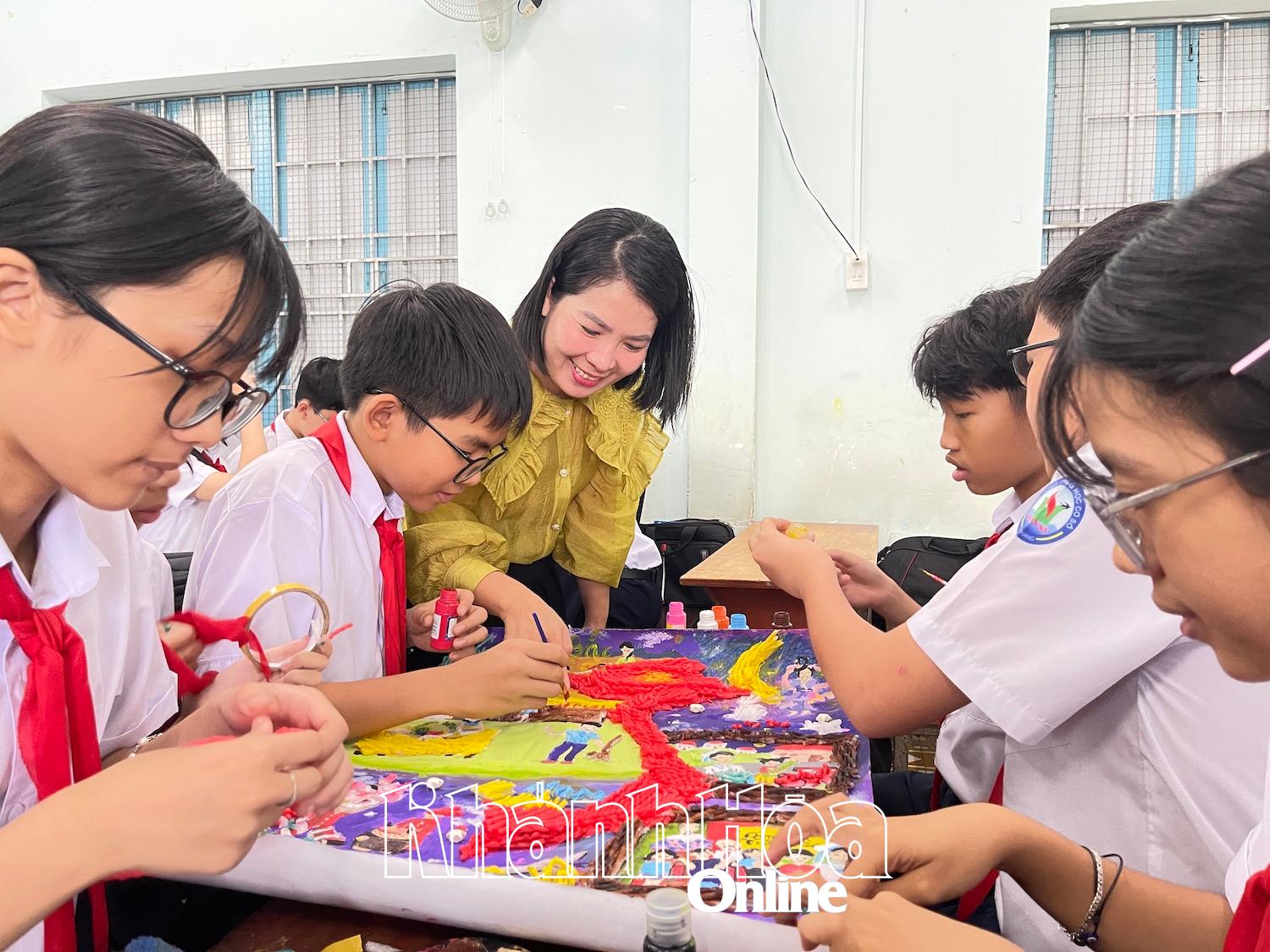 Cô Vân và các em học sinh thảo luận tô màu cho tranh