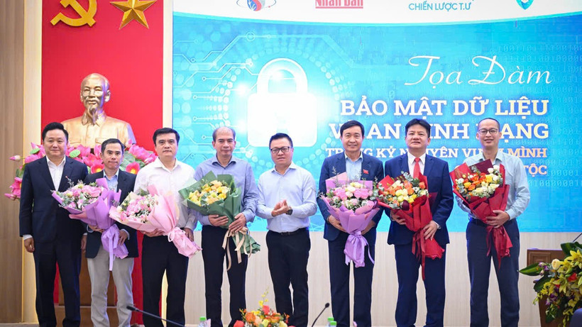 និពន្ធនាយកនៃកាសែត Nhan Dan លោក Le Quoc Minh និងជានិពន្ធនាយករងនៃកាសែត Nhan Dan លោក Phan Van Hung ជូនផ្កាដល់វាគ្មិននៃសិក្ខាសាលាស្តីពីសុវត្ថិភាពទិន្នន័យ និងសន្តិសុខបណ្តាញ។ (រូបថត៖ THANH DAT)