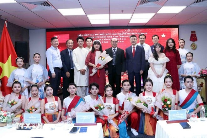 Các đại biểu chụp ảnh lưu niệm cùng các em sinh viên tham gia biểu diễn văn nghệ tại buổi gặp mặt. (Ảnh: Xuân Khu/TTXVN)