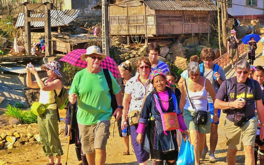 Du khách quốc tế trải nghiệm tour trekking Sa Pa với một hướng dẫn viên nữ địa phương.