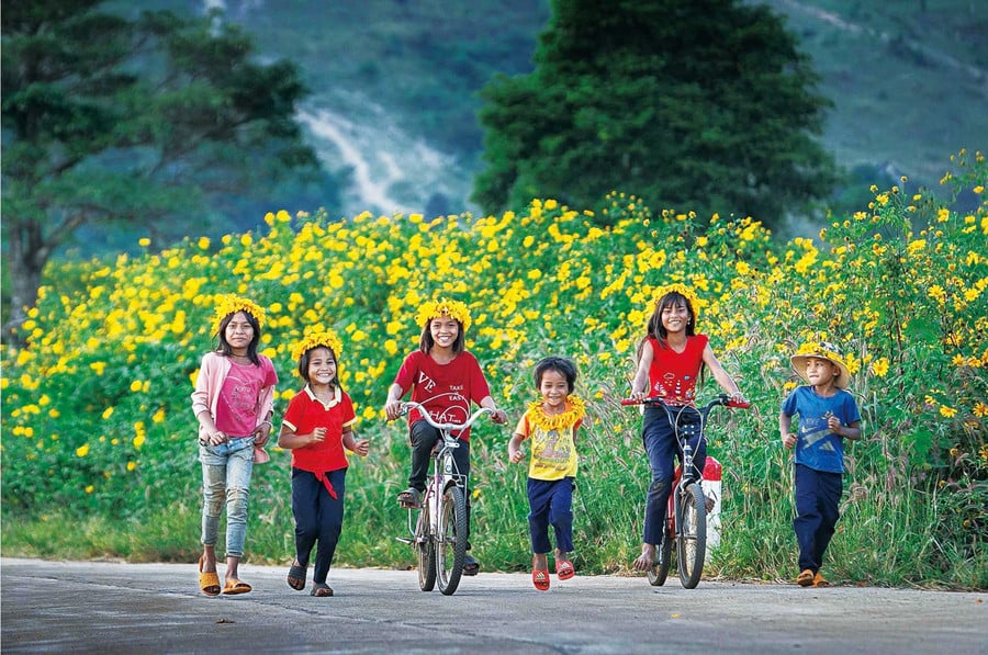Các em nhỏ bên hoa dã quỳ dưới chân núi Chư Đang Ya. Ảnh: Nguyễn Linh Vinh Quốc