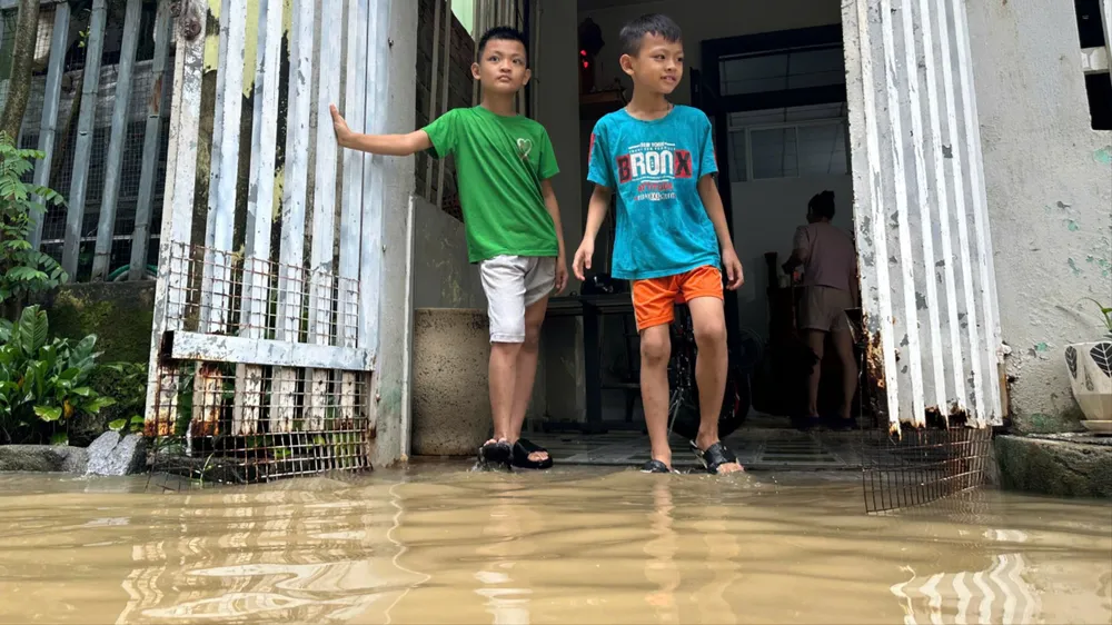 Nước dâng cao, tràn vào tận hiên nhà các hộ dân đường Mẹ Suốt. Ảnh: PHẠM NGA