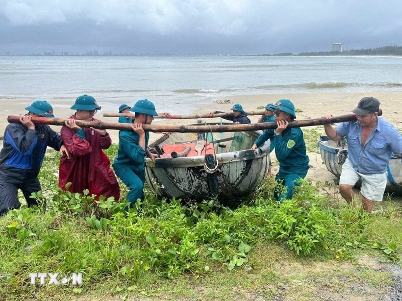 Hai Van ward authorities help fishermen bring their boats ashore to avoid the storm. (Photo: VNA)