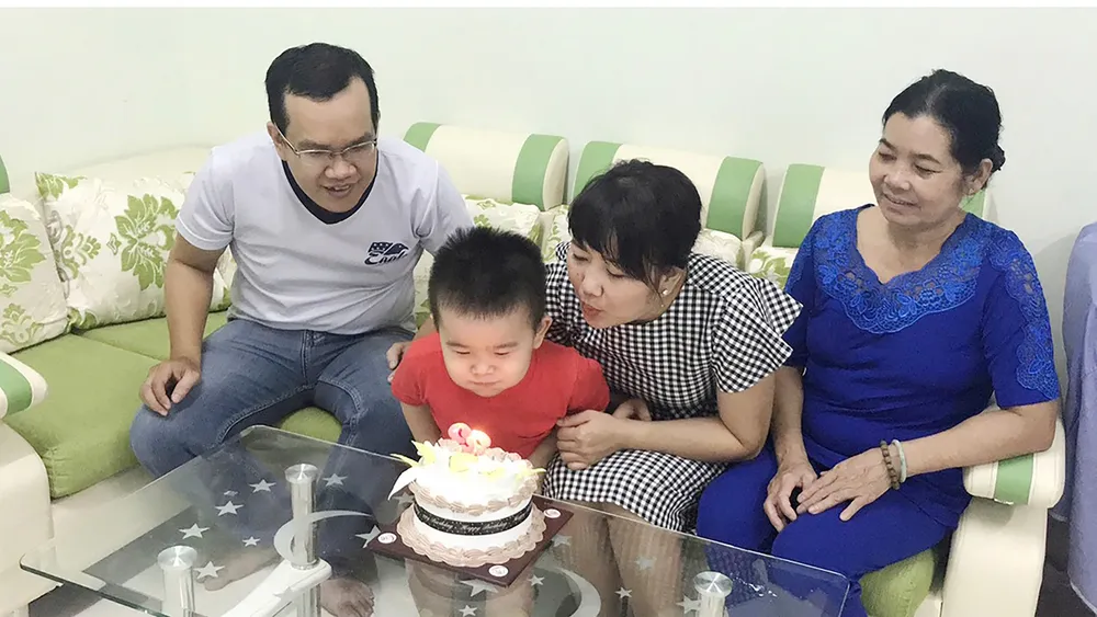 Mann und Frau feiern den Geburtstag ihres Enkels mit der Großmutter. Foto: DUNG PHUONG