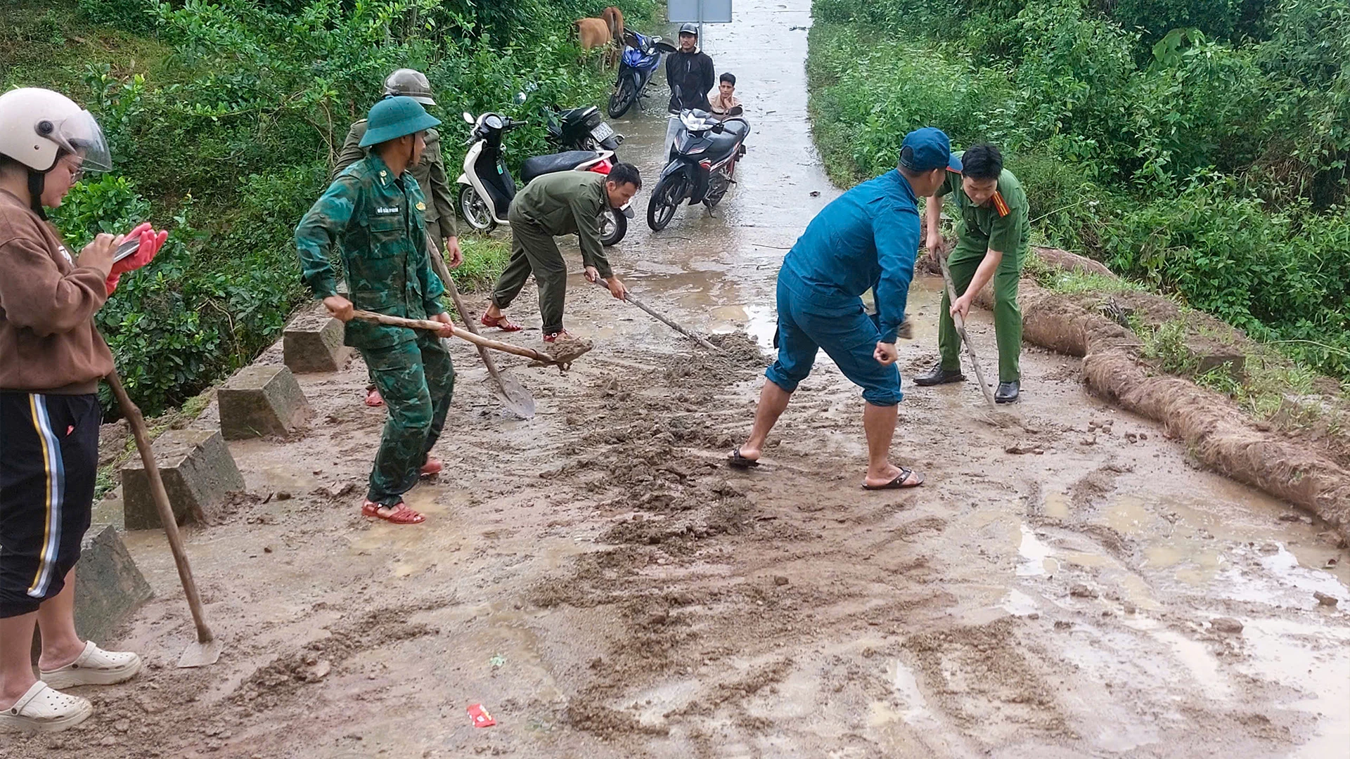 ឆ្មាំព្រំដែន និងកម្លាំងមូលដ្ឋានបោសសម្អាតភក់ល្បាប់នៅតាមដងផ្លូវព្រំដែន - រូបភាព៖ N.H