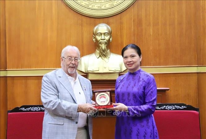 Phó Chủ tịch Ủy ban Trung ương MTTQ Việt Nam Hà Thị Nga trao quà tặng Bí thư Đảng Cộng sản Anh Robert Griffiths. (Ảnh: TTXVN)