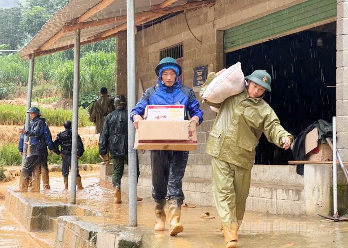 Lực lượng chức năng hỗ trợ người dân chuyển đồ đạc tới nơi an toàn.