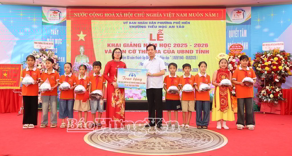 គណៈកម្មាធិការសុវត្ថិភាពចរាចរណ៍ខេត្ត ប្រគល់មួកសុវត្ថិភាព និងសៀវភៅណែនាំទំនាក់ទំនងគ្រួសារ ស្តីពីសុវត្ថិភាពចរាចរណ៍ ដល់សិស្សានុសិស្សនៃសាលាបឋមសិក្សាអានតៅ (វួដផូហៀន)។ រូបថត៖ ផាម ដូង