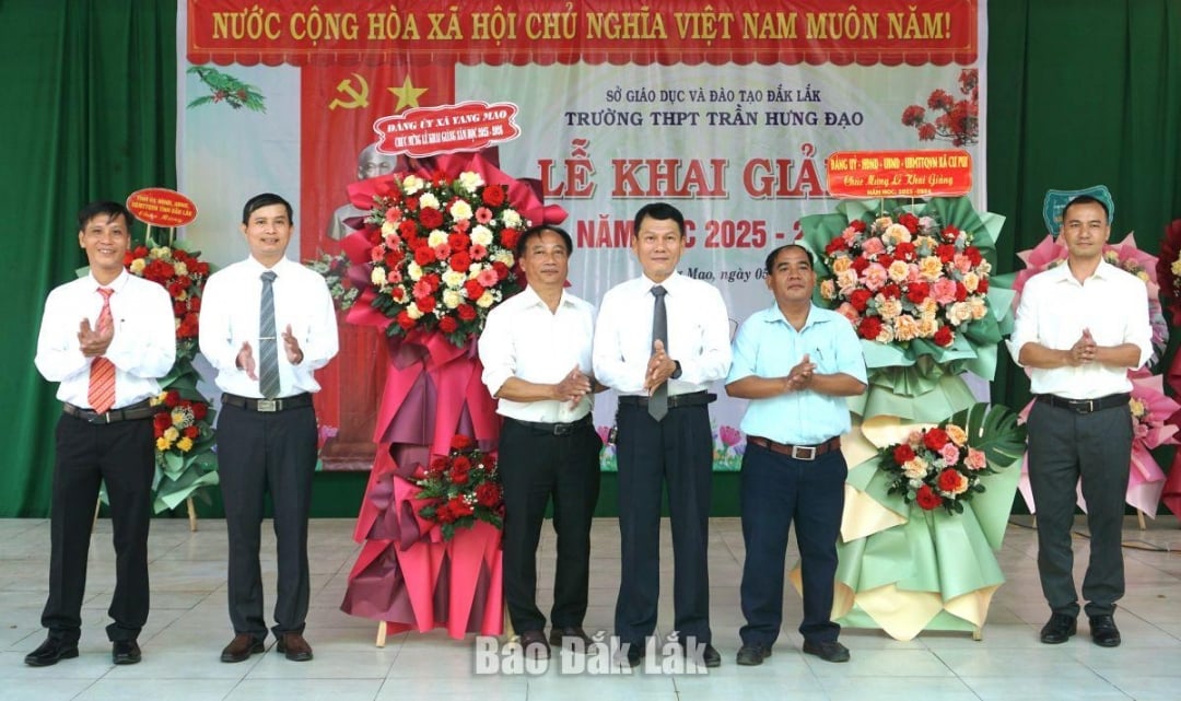 Đại diện lãnh đạo xã Yang Mao và Cư Pui tặng hoa chúc mừng 850 học sinh Trường THPT Trần Hưng Đạo.