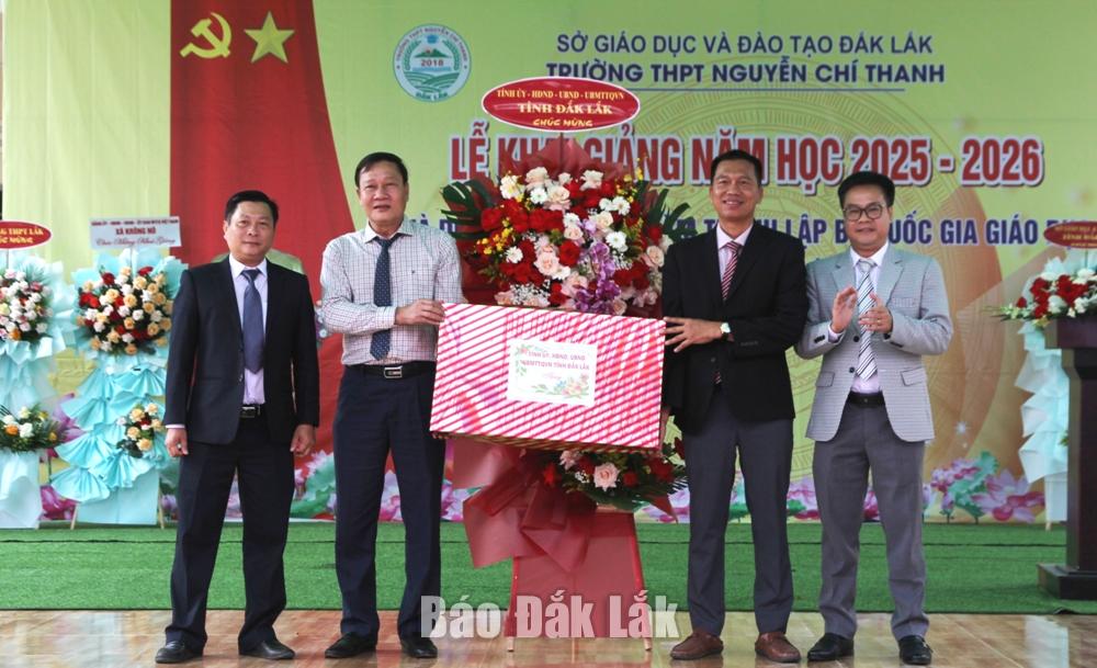 Ủy viên Ban Thường vụ Tỉnh ủy, Phó Chủ tịch Thường trực HĐND tỉnh Trần Phú Hùng trao hoa và quà của tỉnh tặng nhà trường.