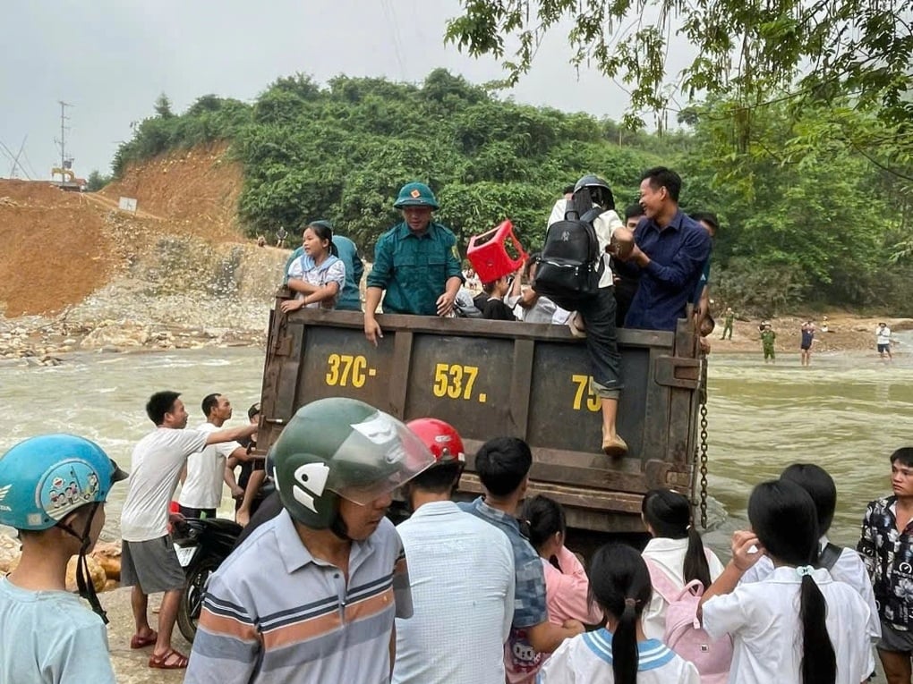 Dùng máy múc, xe công an và ô tô tải chở học sinh vượt lũ đi khai giảng - 1