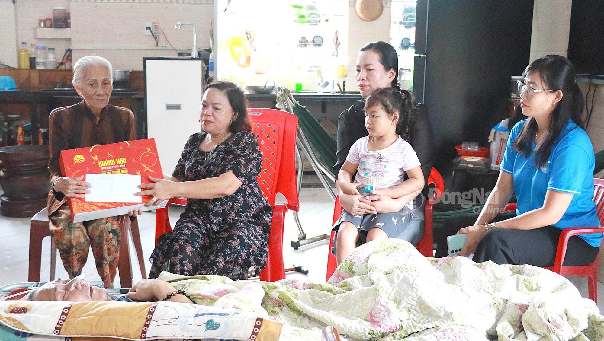 Bà Nguyễn Thị Hương và lãnh đạo Hội Liên hiệp phụ nữ phường Phước Bình thăm, tặng quà một thành viên người khuyết tật ở địa phương bị tai nạn. Ảnh: Quang Minh