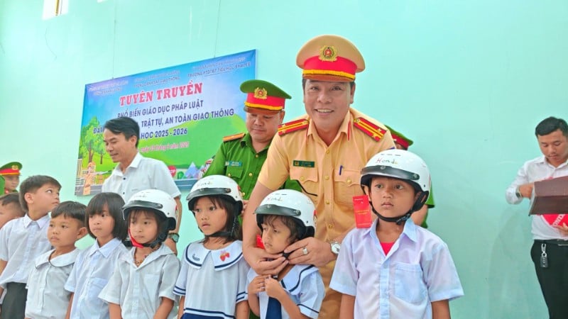 Polisi Komune A Vuong berkoordinasi dengan Tim Polisi Lalu Lintas Jalan No. 3, Departemen PC08, Kepolisian Kota Da Nang untuk memberikan helm kepada pelajar.
