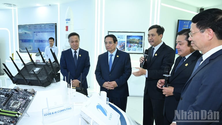 Thủ tướng Phạm Minh Chính nghe lãnh đạo Tập đoàn VNPT giới thiệu về các thiết bị công nghệ mới. (Ảnh: TRẦN HẢI).