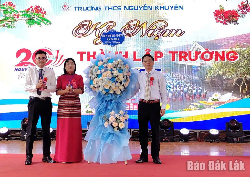 Naib Pengerusi Jawatankuasa Rakyat Komune Ea Kar Nguyen Thanh Duong (kulit kiri) menyampaikan bakul bunga daripada Jawatankuasa Parti - Majlis Rakyat - Jawatankuasa Rakyat - Jawatankuasa Front Tanah Air Vietnam komune untuk mengucapkan tahniah kepada Sekolah Menengah Nguyen Khuyen.