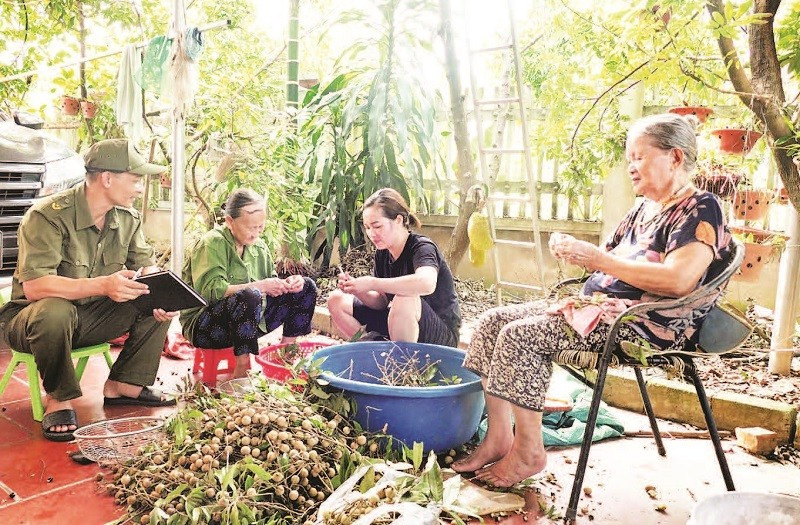 Mr. Pham Van Cuong (far left) regularly visits households to monitor the local security and order situation.