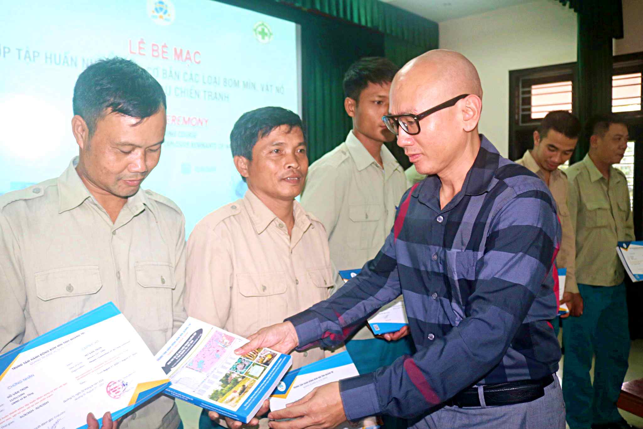 Herr Dinh Ngoc Vu, stellvertretender Direktor der Provinz QTMAC, überreichte den Schülern Abschlusszertifikate und Bücher zur Identifizierung von Bomben, Minen und Sprengstoffen – Foto: NVCC
